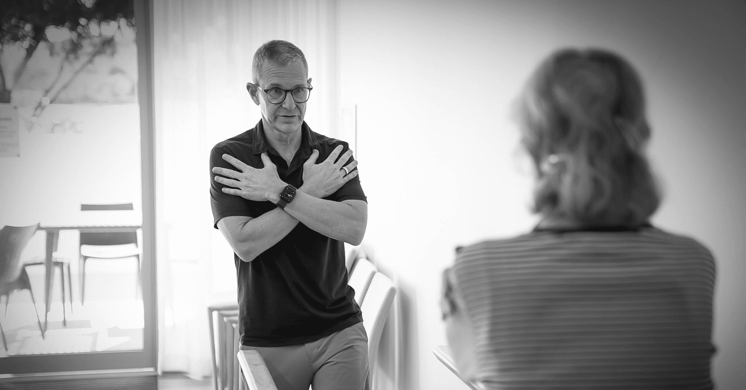 Clinician consulting with an older adult during a home physiotherapy visit.