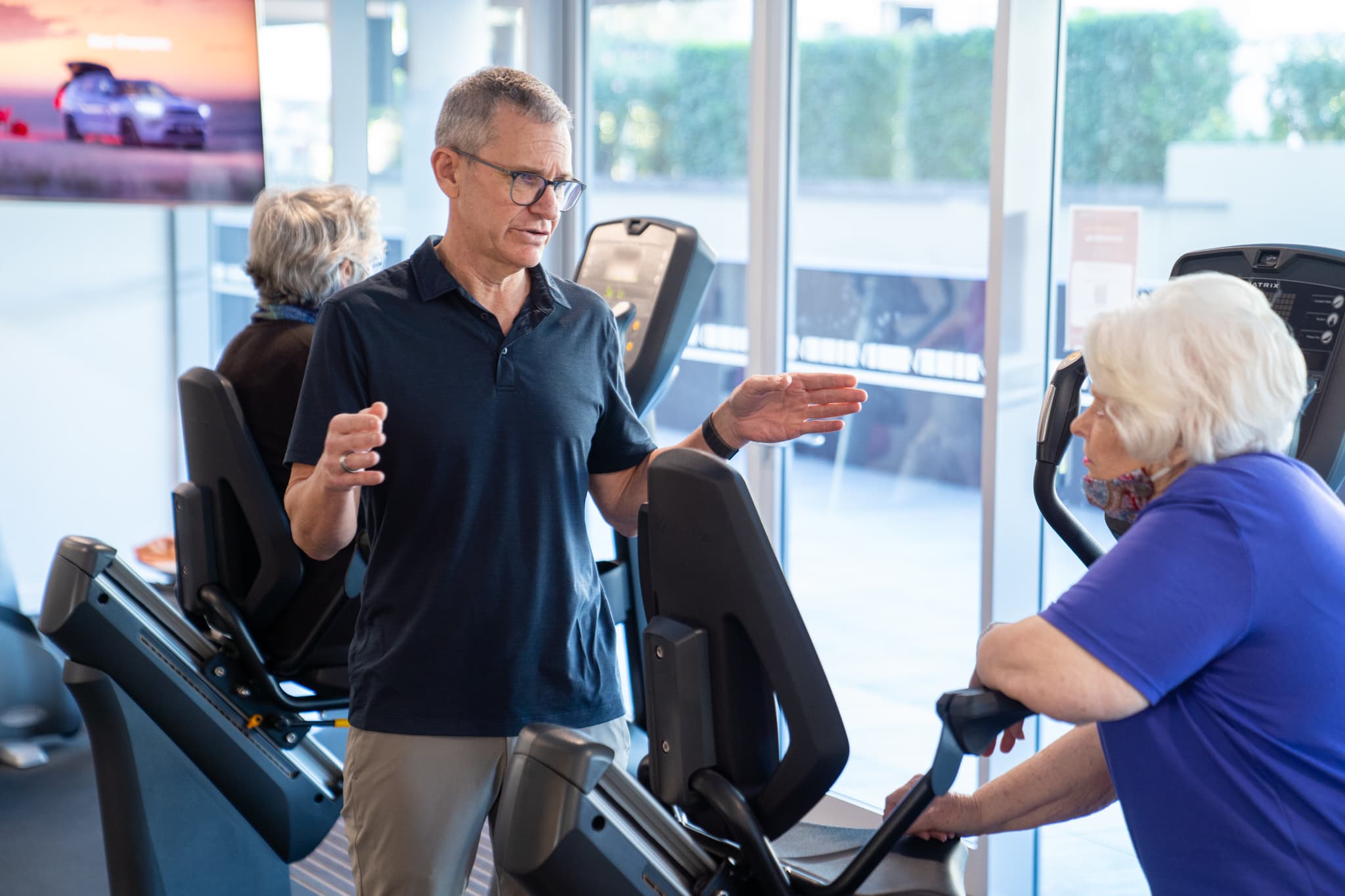 Clinician supporting an older adult through a community-linked movement program.